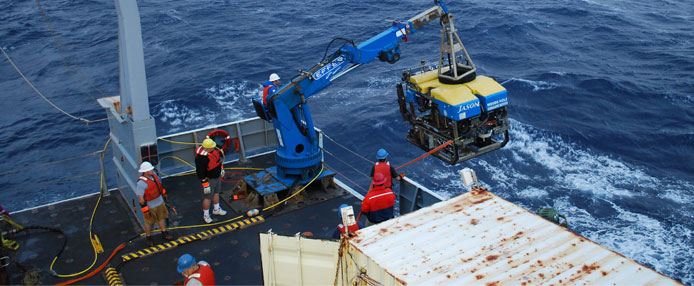 Ship crane lowering equipment into the ocean